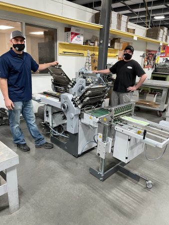 Tony Collins, production manager, and Nick Larsen, bindery operator of Peczuh Printing with the newly installed Stahlfolder Ti 36from Heidelberg.